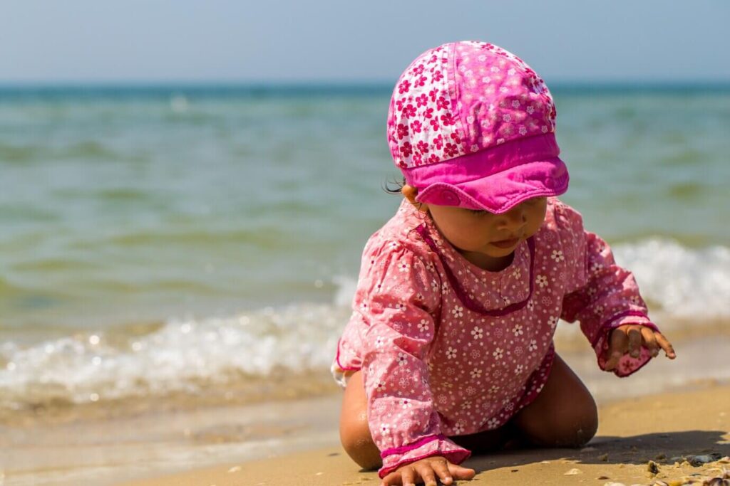 Baby in Ägypten spielt im Sand vor dem Meer